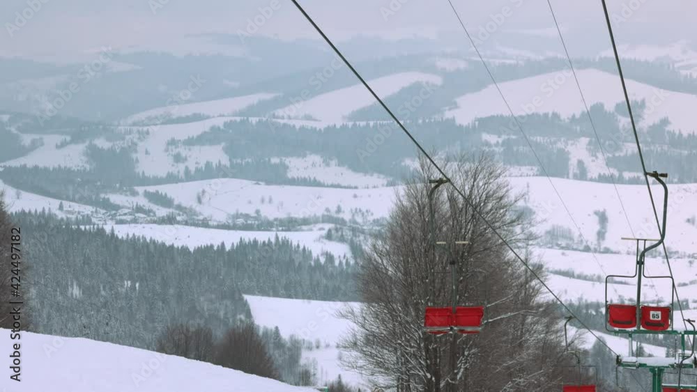 View of the colored lift against the background of a mountain spruce forest and gray sky in the beautiful Carpathians View of the colored lift against the background of a mountain spruce forest and gray sky in the beautiful Carpathians