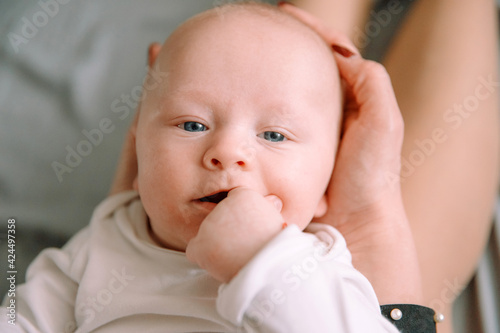 Little baby lies on mother's feet and looks at the camera