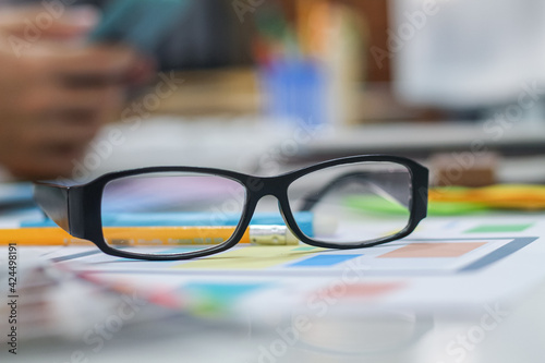 The glasses placed on the desk are pre-made glasses for working in order to increase the field of view for designers who need work eyesight. Concept of wearing eyeglasses to increase the visual acuity