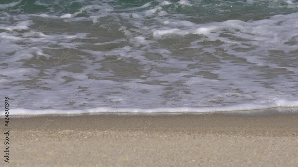 Foamy Waves Washing Sandy Beach In Gangneung, South Korea - close up Foamy Waves Washing Sandy Beach In Gangneung, South Korea - close up