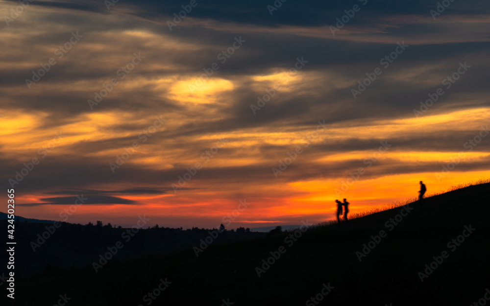 silhouette of a person walking on a hill