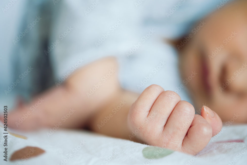 close-up view of hand of newborn baby resting on bed