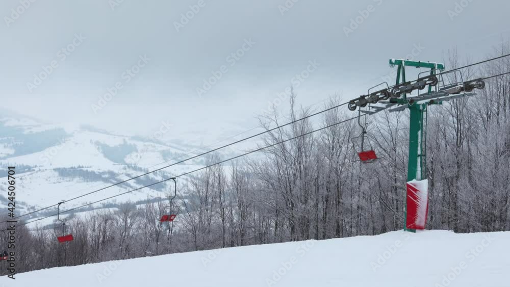View of the colored lift against the background of a mountain spruce forest and gray sky in the beautiful Carpathians View of the colored lift against the background of a mountain spruce forest and gray sky in the beautiful Carpathians
