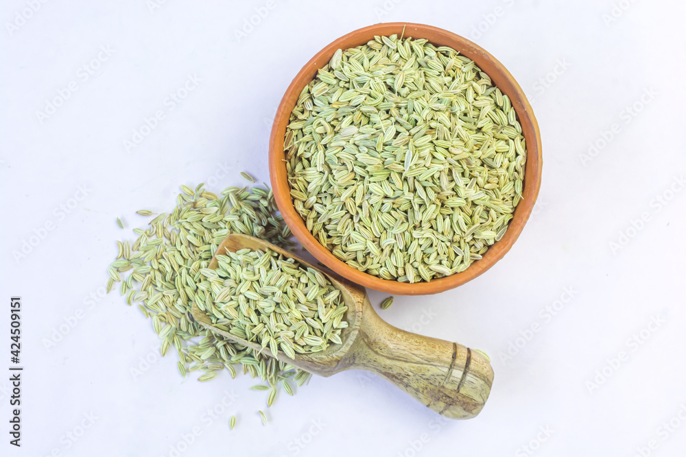 Dried organic fennel seeds or saunf in a earthen bowl on white background. Dried organic fennel seeds or saunf in a earthen bowl on white background.