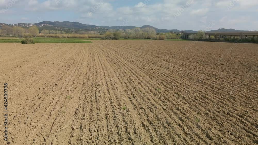 Low Aerial dolly right shot of plowed field prepared for cultivation Low Aerial dolly right shot of plowed field prepared for cultivation