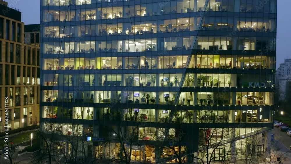 The view from the drone on the windows of a skyscraper with office space and people working at computers, the camera moves from the bottom to the top panaramiruya buildings and office windows. 4K Reso The view from the drone on the windows of a skyscraper with office space and people working at computers, the camera moves from the bottom to the top panaramiruya buildings and office windows. 4K Reso