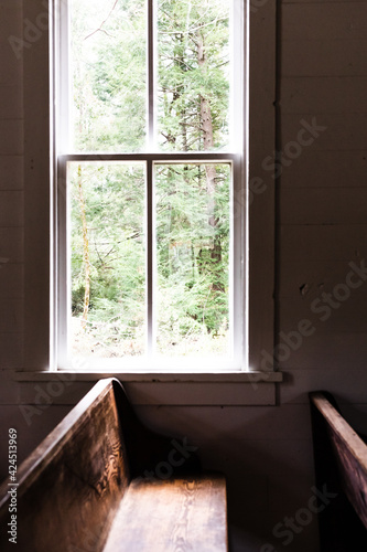Empty church pew with light shining on it through the window