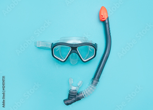Diving mask with snorkel on a turquoise blue background. minimalistic photo of a mask and snorkel for swimming in a pool or sea with a central composition.Concept of summer tropical seaside recreation