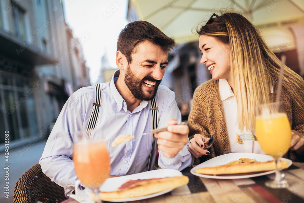 Young couple sitting in a restaurant eating pizza Young couple sitting in a restaurant eating pizza