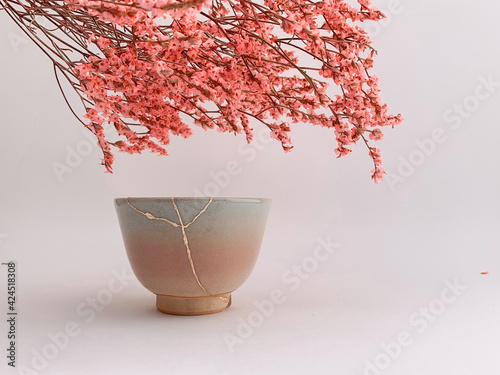 Kintsugi, Japanese Hanami flowers with real gold restored pottery, golden scarsa and cherry blossoms photo