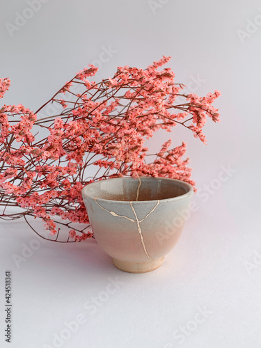 Kintsugi, Japanese Hanami flowers with real gold restored pottery, golden scarsa and cherry blossoms photo