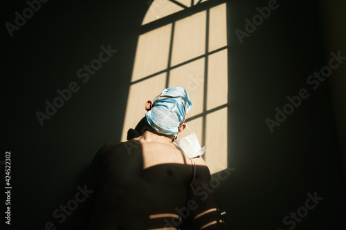 desperate person with mask at home due to the closure of the pandemic in times of covid. quarantine