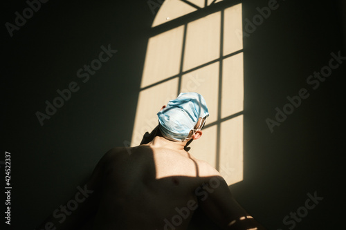 desperate person with mask at home due to the closure of the pandemic in times of covid. quarantine