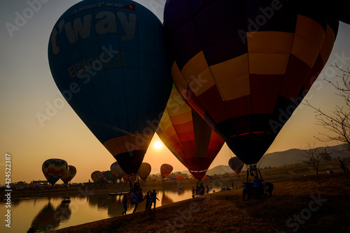 Silhouette hot air balloon over mountains lake in sunset sky