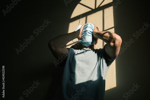 desperate person with mask at home due to the closure of the pandemic in times of covid. quarantine