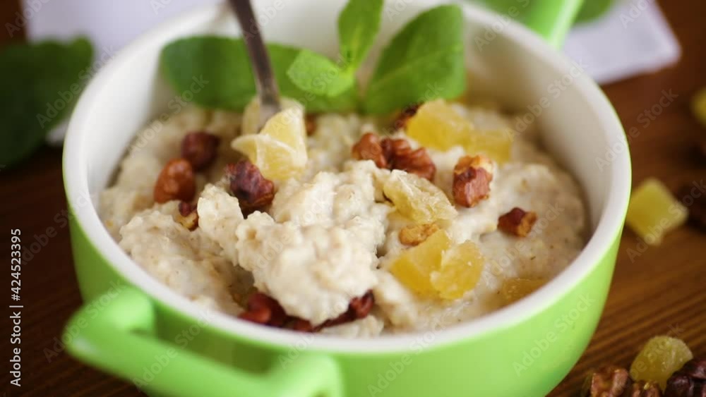 cooked boiled sweet oatmeal with nuts and candied fruits in a bowl cooked boiled sweet oatmeal with nuts and candied fruits in a bowl