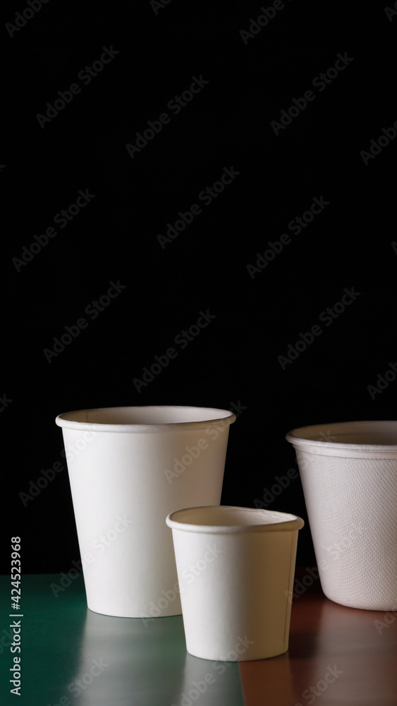 Compostable disposable container. Biodegradable organic container, glasses, spoons. Environmental friendly. 100% compostable cups. black background Compostable disposable container. Biodegradable organic container, glasses, spoons. Environmental friendly. 100% compostable cups. black background