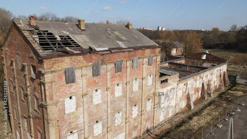 Distillery in Loshitsa Park. Fly over the destroyed old buildings. The collapsed roof and crumbling brick are visible. Lifeless spring landscape Distillery in Loshitsa Park. Fly over the destroyed old buildings. The collapsed roof and crumbling brick are visible. Lifeless spring landscape