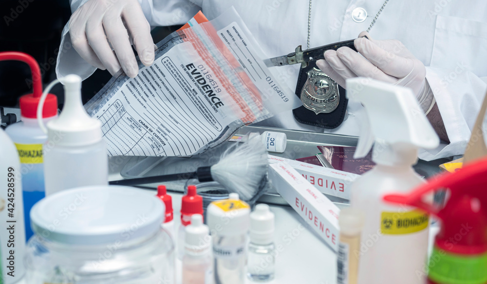 Fototapeta premium police scientist extracts knife from evidence bag in crime lab, conceptual image