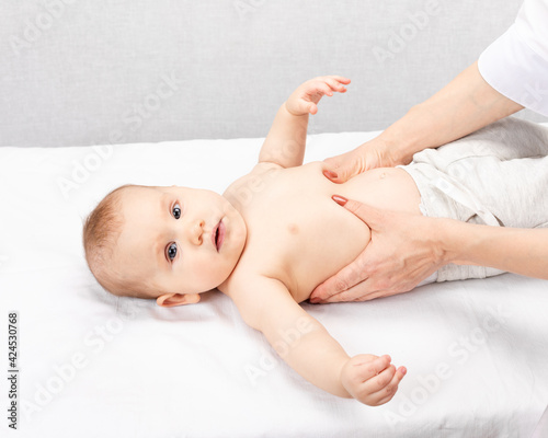 Little baby receiving abdominal massage in pediatric clinic