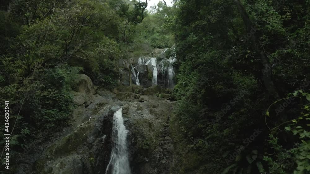 Descending drone view of an epic cascading waterfall in the Caribbean jungle of Tobago Descending drone view of an epic cascading waterfall in the Caribbean jungle of Tobago