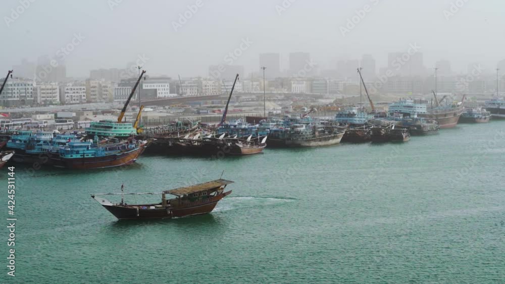 Dhow Fishing Boat Turns To PArk At Crowded Port In Dubai Creek In The Morning In Dubai, UAE. - wide shot Dhow Fishing Boat Turns To PArk At Crowded Port In Dubai Creek In The Morning In Dubai, UAE. - wide shot