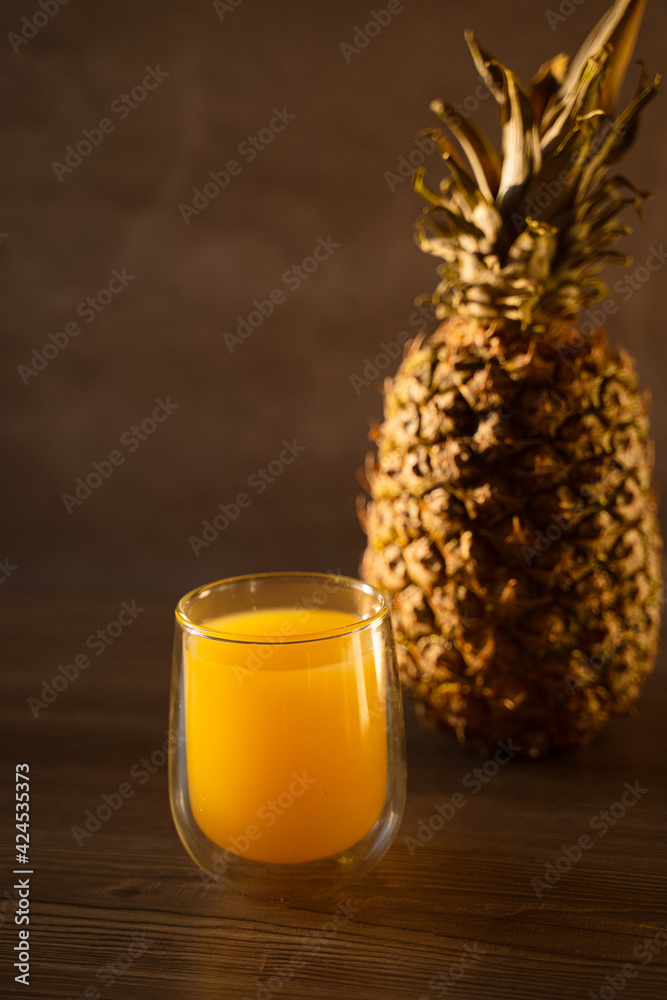Pineapple fruit and juice in double glass cup. Tropical fruit . Pouring yellow tropical juice into glass. Pineapple fruit and juice in double glass cup. Tropical fruit . Pouring yellow tropical juice into glass.