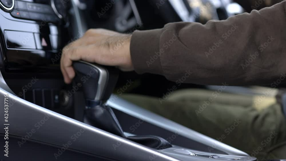 Young man finished the driving car he hand control the stick shift transmission to parking. Male hand changing gear to p mode to parking car. Young man finished the driving car he hand control the stick shift transmission to parking. Male hand changing gear to p mode to parking car.
