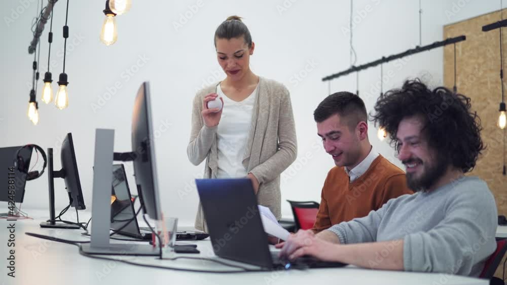 Young developer sharing new ideas about project to his partners in office working room. Multiethnic coworkers discussing over new business project in modern loft interior.
