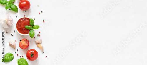 Long wide banner with homemade tomato sauce with fresh aromatic basil, cherry tomatoes, peppercorn and garlic on white marble background. Culinary blog banner concept.