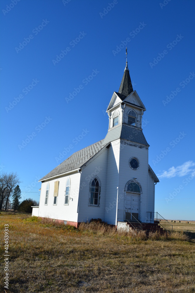Old abandoned church with steeple and broken stained glass windows