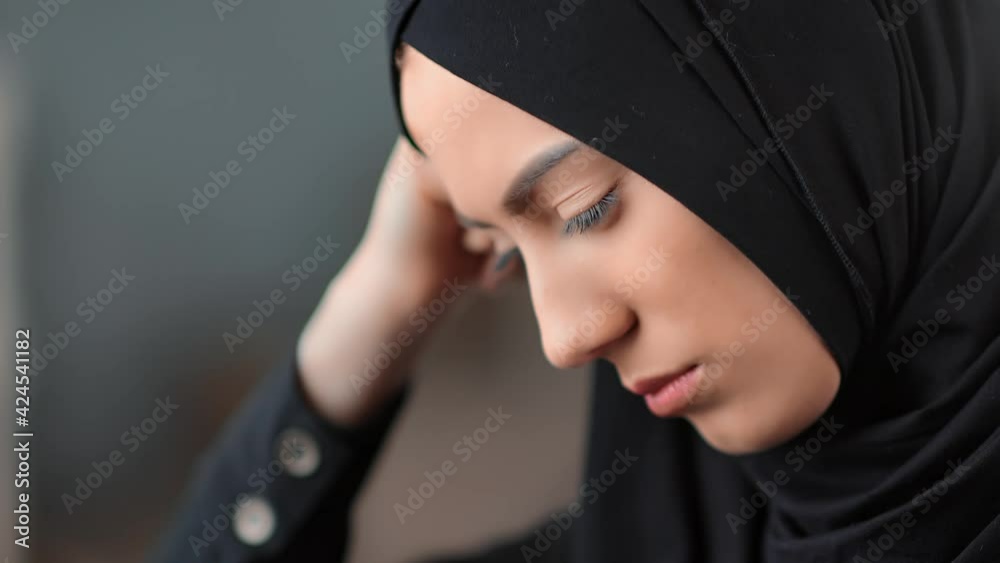 Closeup face cute Muslim woman with perfect skin having head pain ache. Shot with RED camera in 4K Closeup face cute Muslim woman with perfect skin having head pain ache. Shot with RED camera in 4K