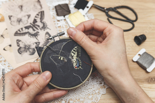 Woman embroider a butterfly. Process of making handmade embroidery. Hobby. Sewing tools. Remote home work.