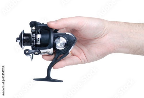 Fishing reel for fishing rod in hand on white background isolation