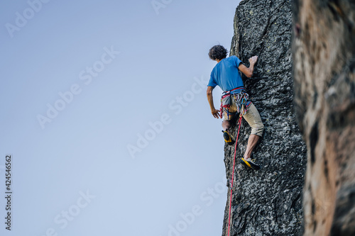 A climber on a steep rock. Rock climbing, extreme adrenaline sport climbing.