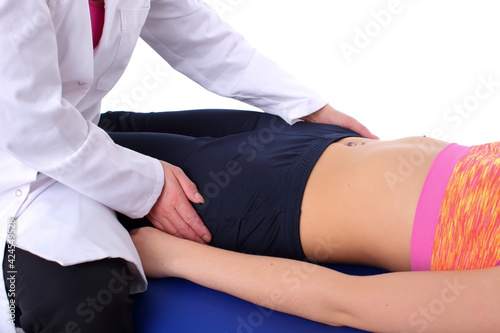 The physiotherapist performs a relaxing massage of the hip muscles by gently rocking them from side to side