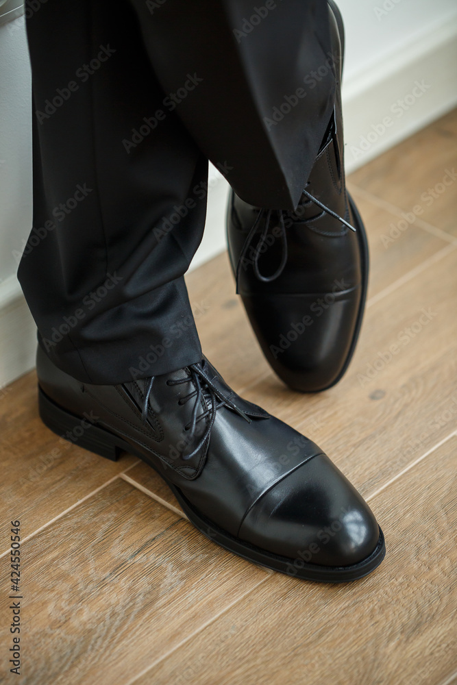Male businessman puts on stylish shoes. Clothes for men