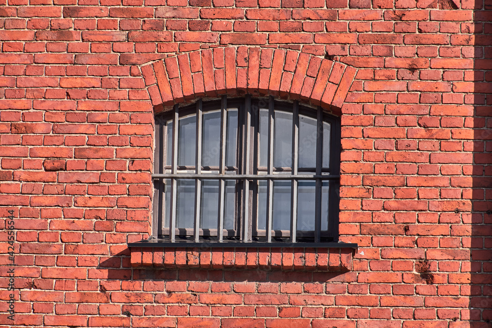 The old prison window on the red brick wall in Helsinki, Finland.