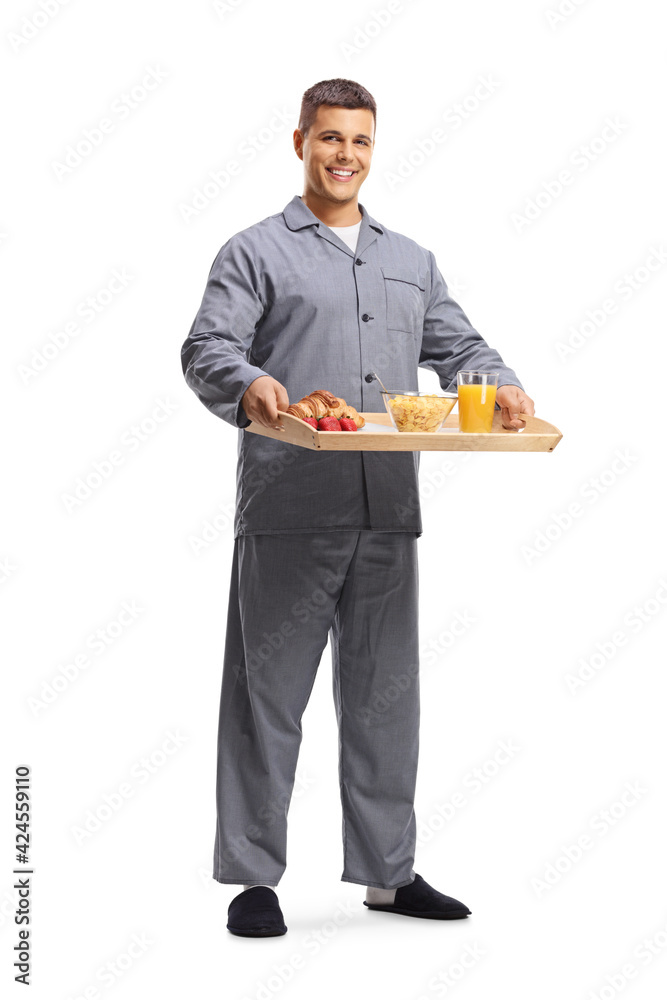 Full length portrait of a smiling young man in pajamas holding a breakfast tray Full length portrait of a smiling young man in pajamas holding a breakfast tray