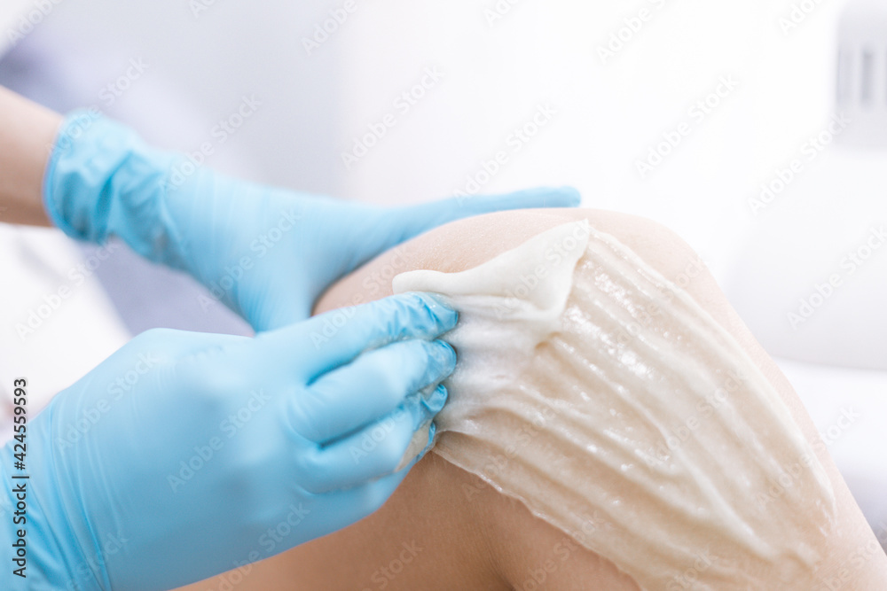 female legs hair removal with sugaring procedure in beauty salon female legs hair removal with sugaring procedure in beauty salon