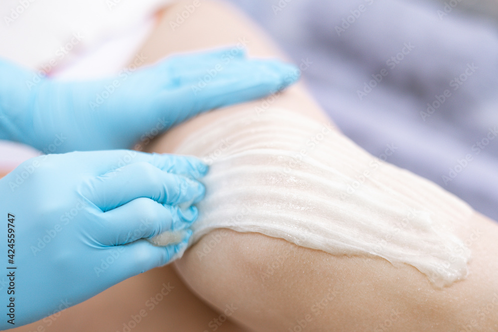 female legs hair removal with sugaring procedure in beauty salon female legs hair removal with sugaring procedure in beauty salon