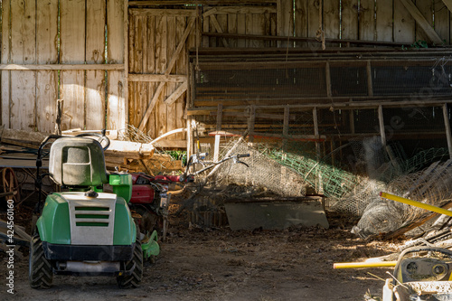 un tracteur et divers outils à l'intérieur d'une grange photo