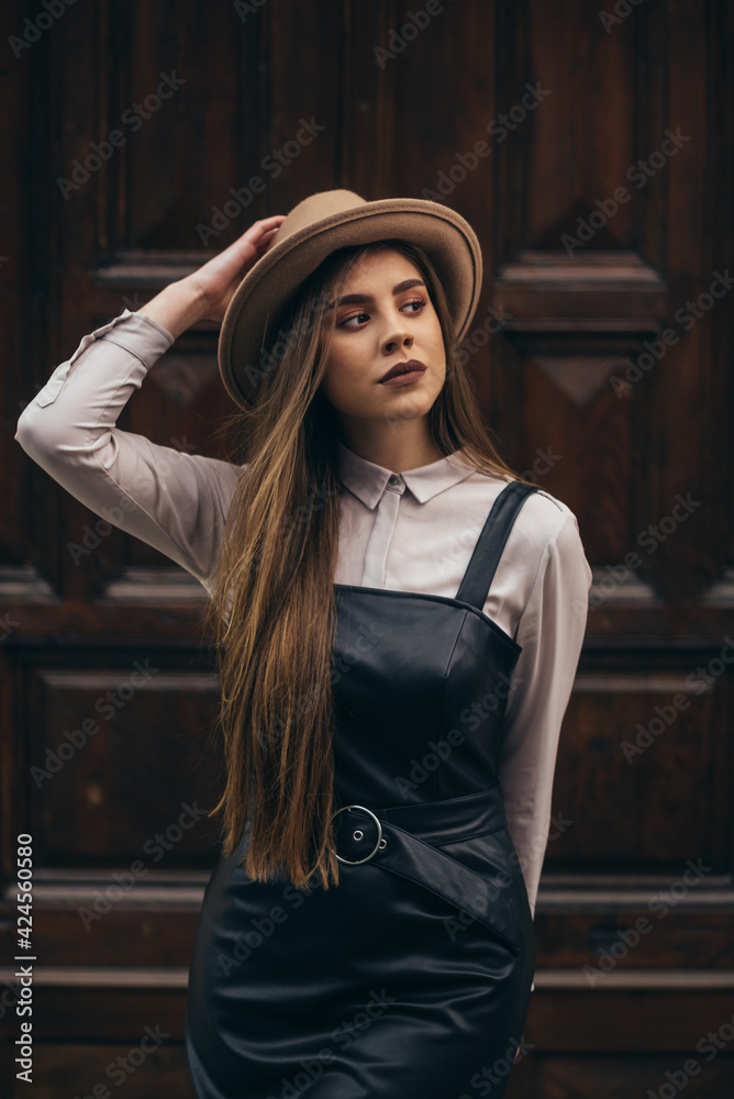 Fototapeta premium Woman wearing dress and a hat walking outside