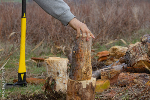 An ax with a yellow-black handle, chopping wood.