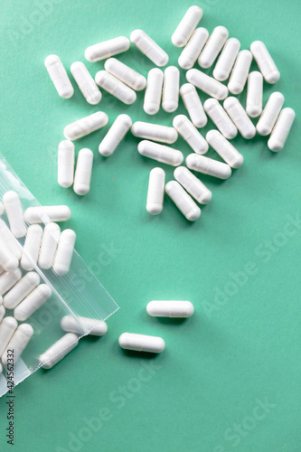 pill capsules scattered on green background