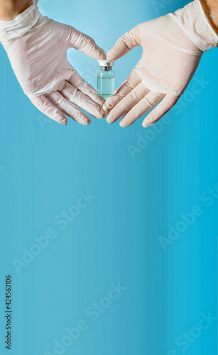 Coronavirus concept, Covid-19. A doctor in medical gloves holds an ampoule with a vaccine.banner