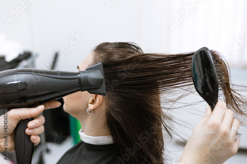 process of drying hair with a hair dryer in a beauty salon after care procedures