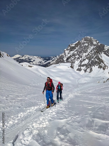 Ski mountaineering couple toward the mountain pass in a nice track with sealskin. Winter landscape in glarus. Snow Skimo © SimonMichael