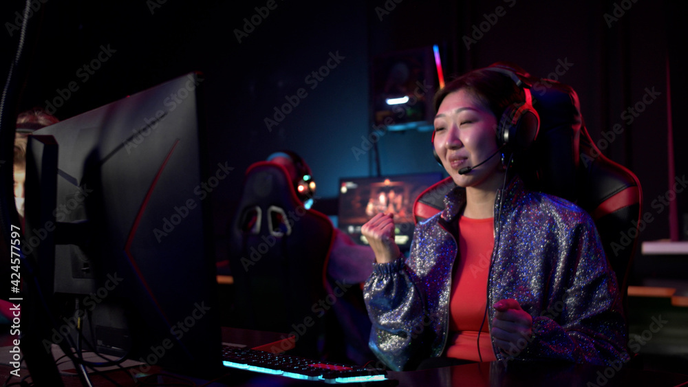 The last seconds of the esports online first face shooter match, the gamer girl in the computer club wins and rejoices