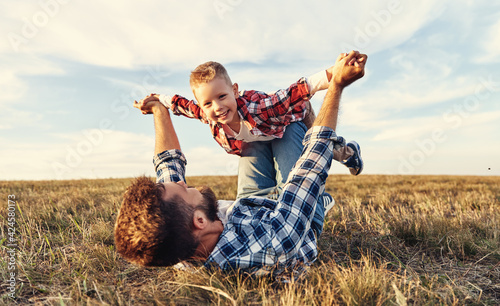 Happy family: father and son in nature in summer
